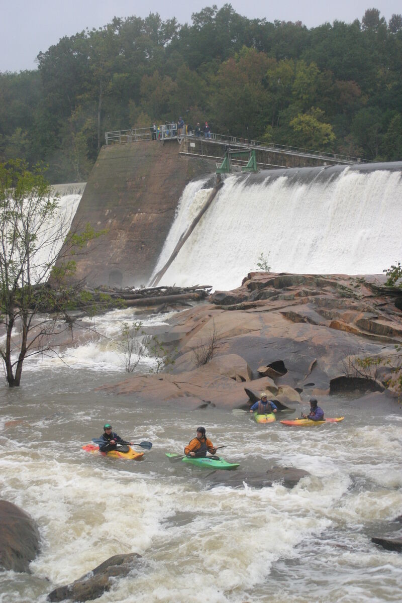 A crowd watches from the dam. 